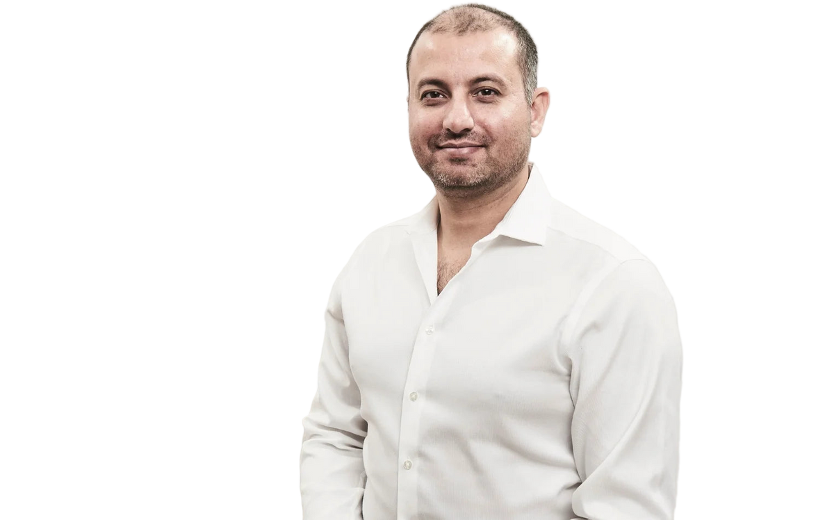 Kapil wearing a white shirt against a plain background